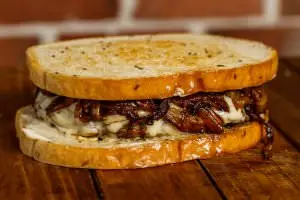 One (1/2 lb.) patty served on rye bread with grilled onions, (2) slices of swiss cheese, and no veggies. Your choice of condiments.