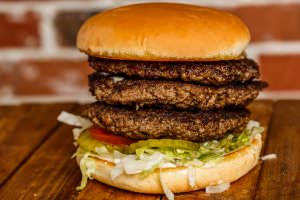 Three (1/2 lb. ) patties bottomed with lettuce, tomatoes, onions, and pickles. Your choice of condiments.