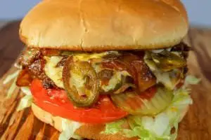 One (1/2 lb.) patty served with grilled onions, jalapeños, and pepper jack cheese, bottomed with lettuce, tomatoes, and pickles. Your choice of condiments.